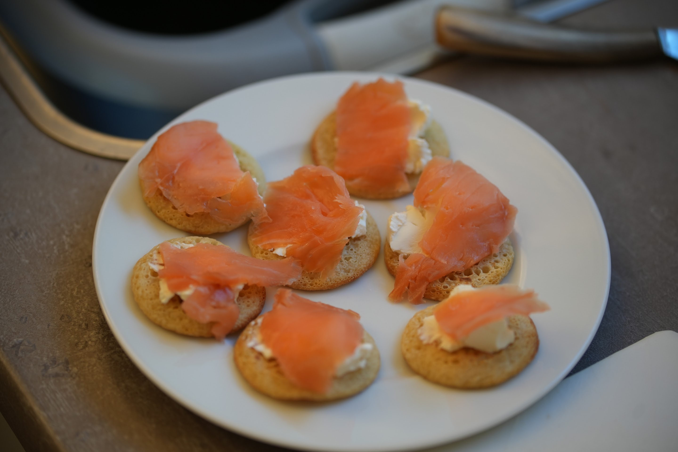 Plate of blinis topped with cream cheese and smoked salmon
