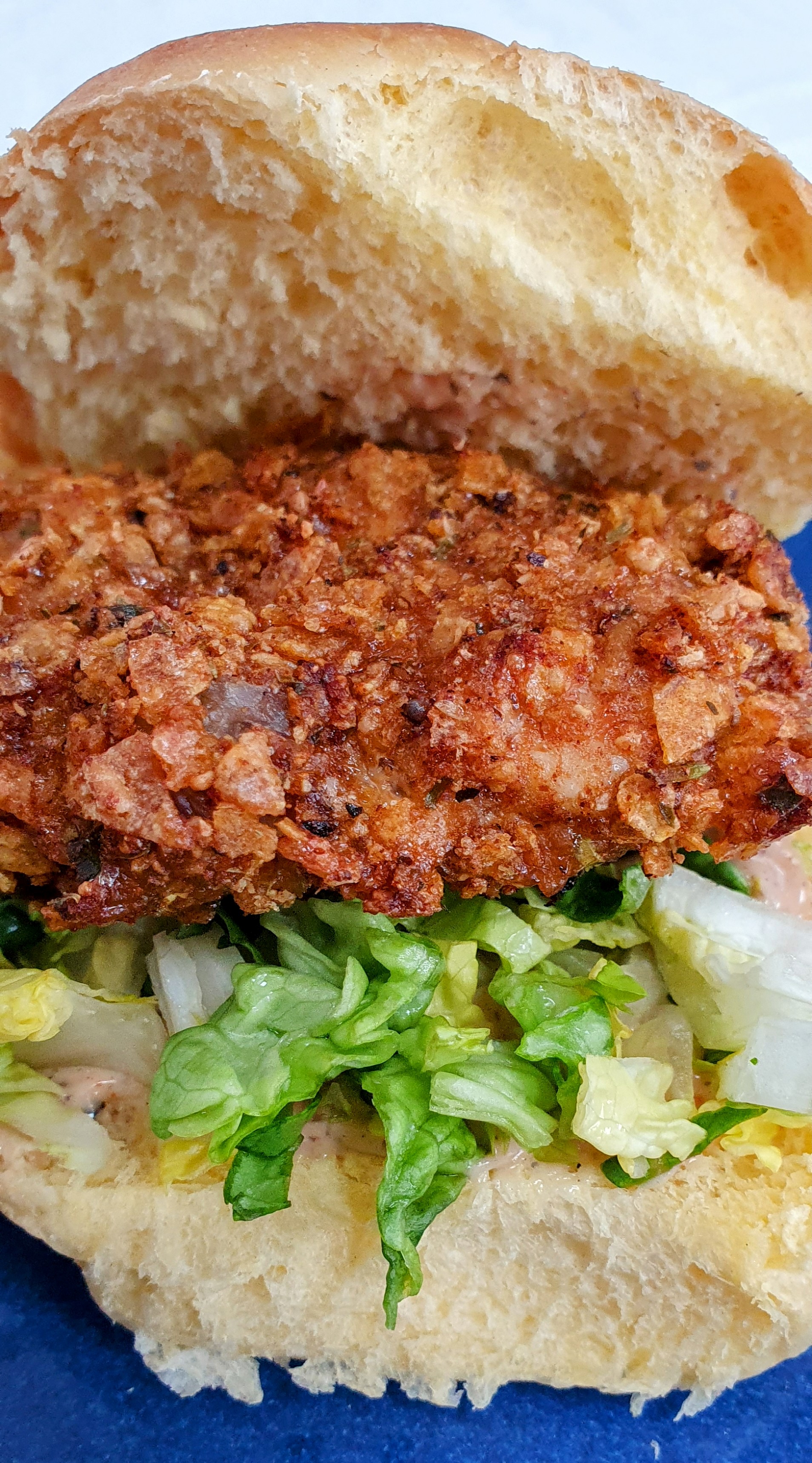 Spicy chicken burger with cornflake crust, crisp lettuce and burger sauce in a brioche bun